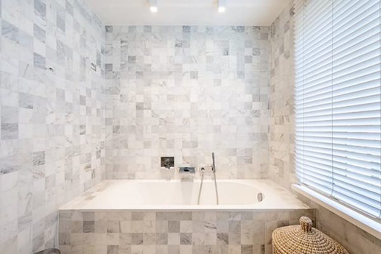 Badkamer met marmeren ligbad